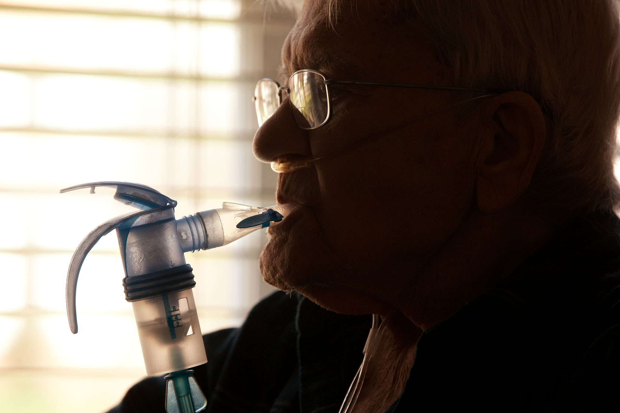 Elderly man using COPD inhaler