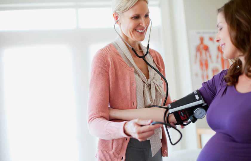 Nurse checking blood pressure of pregnant woman