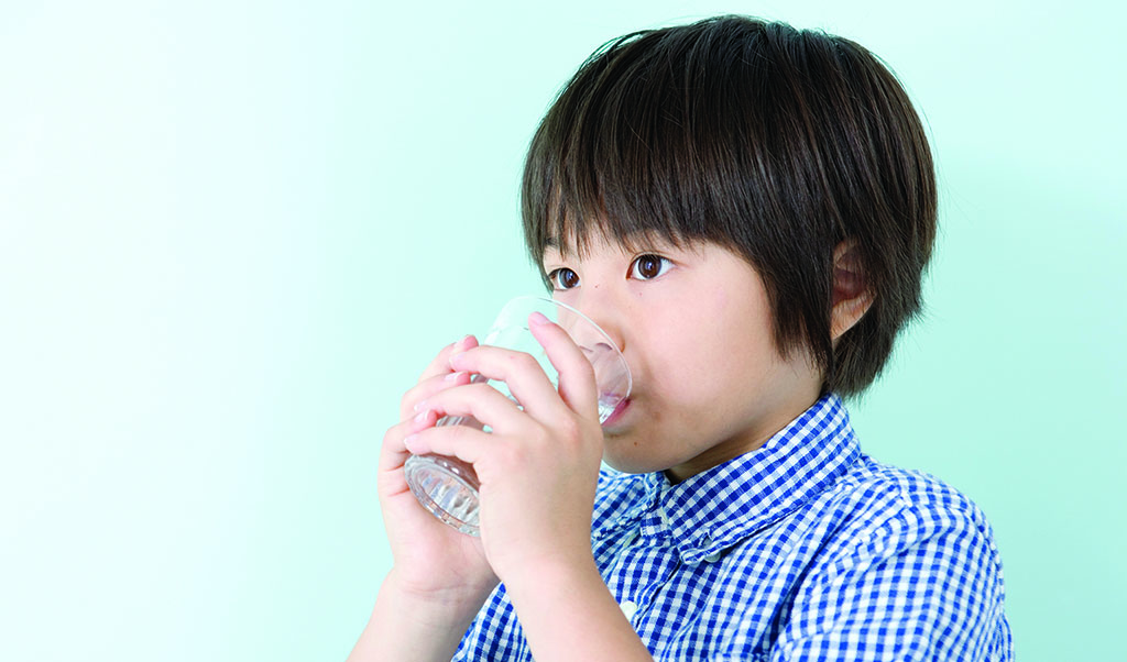 young child drinking glass of water