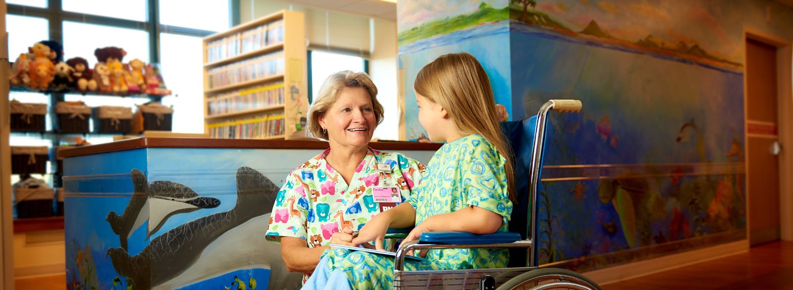 Nurse visiting with young girl in the pediatrics unit at Columbus Regional Hospital.