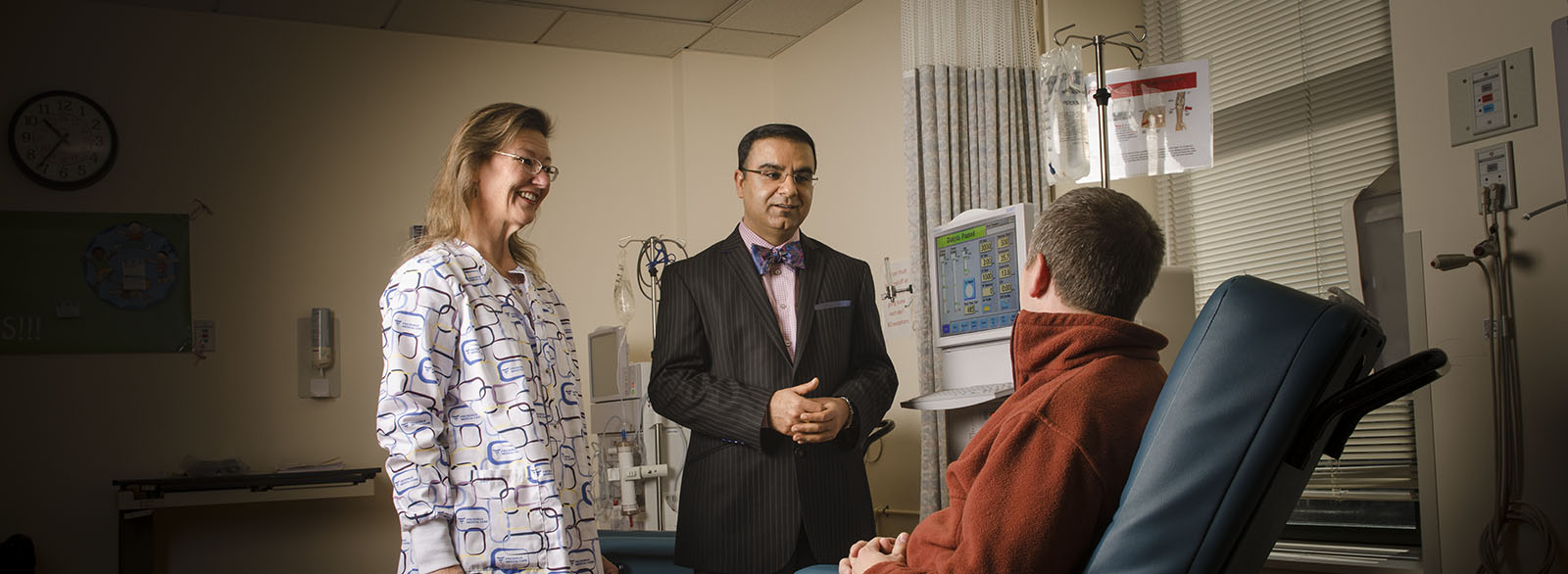 Nurse and doctor speaking to dialysis patient