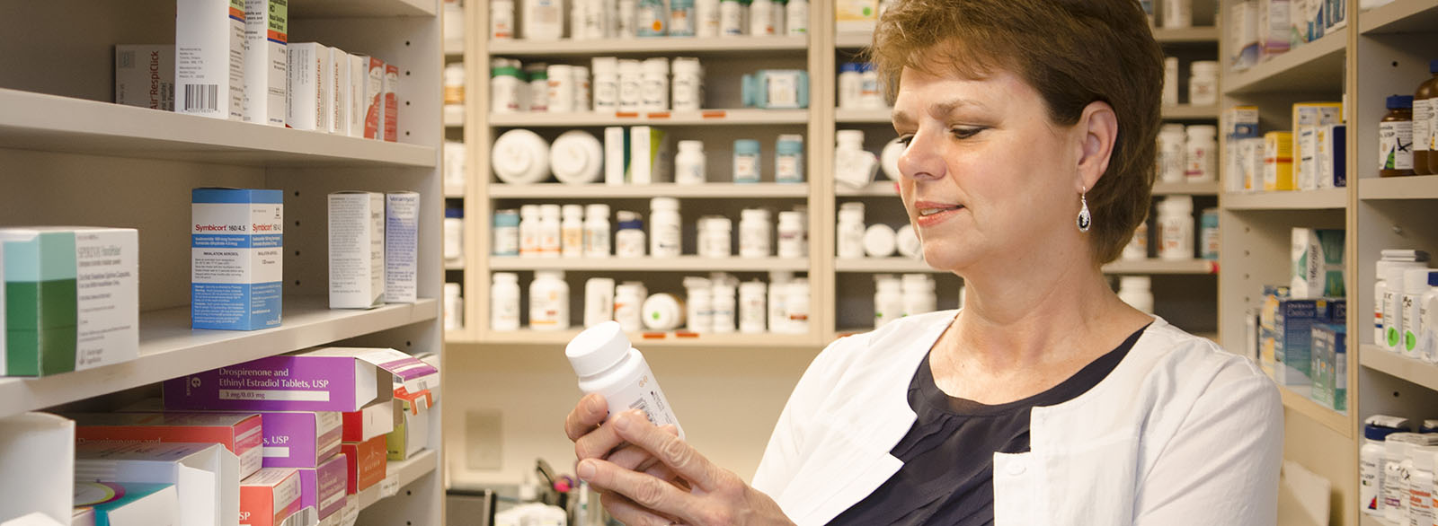 VIMCare pharmacist reading label on bottle of medicine