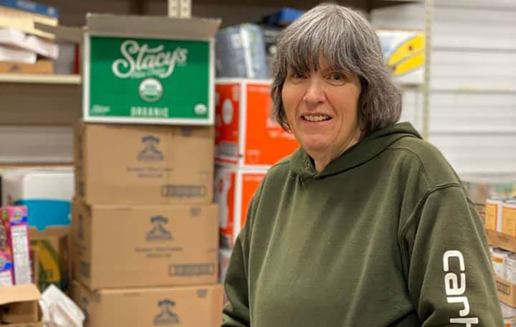 Kathy Sage with shelves of food in the background.