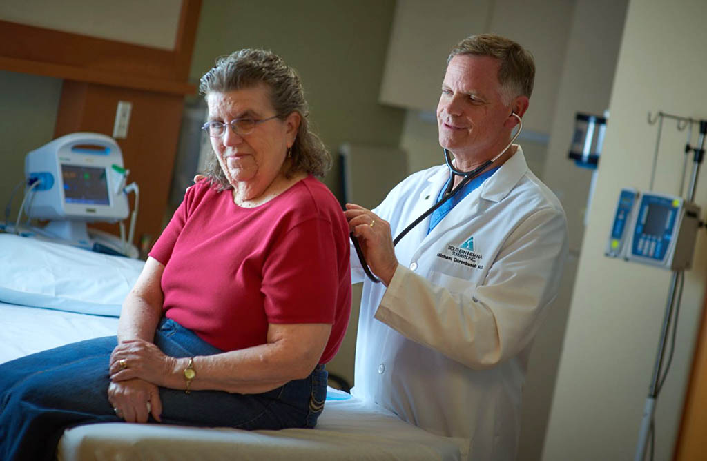 Dr. Michael Dorenbusch examines a female patient.