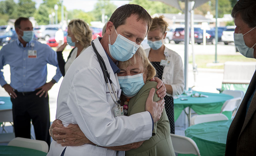 Dr. Lee Kiser hugs CRH board member Sherry Stark during a ceremony in his honor.