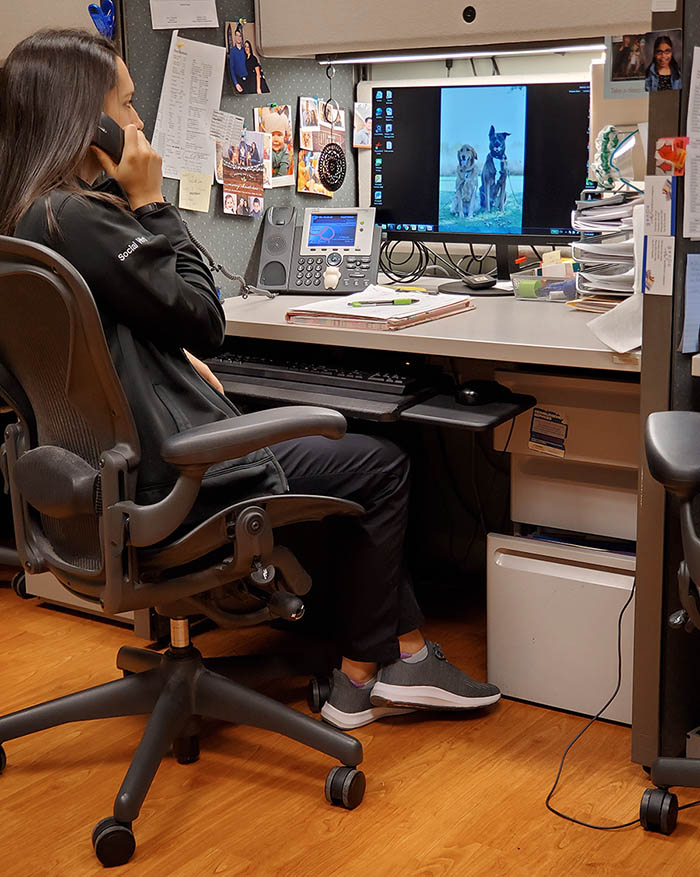 Katy Huck, Social Work Therapist, makes calls at a computer.