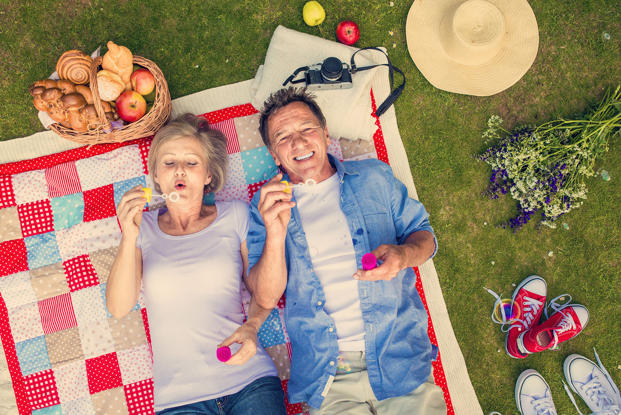 lung Middle-aged couple on picnic blanket blowing bubbles together