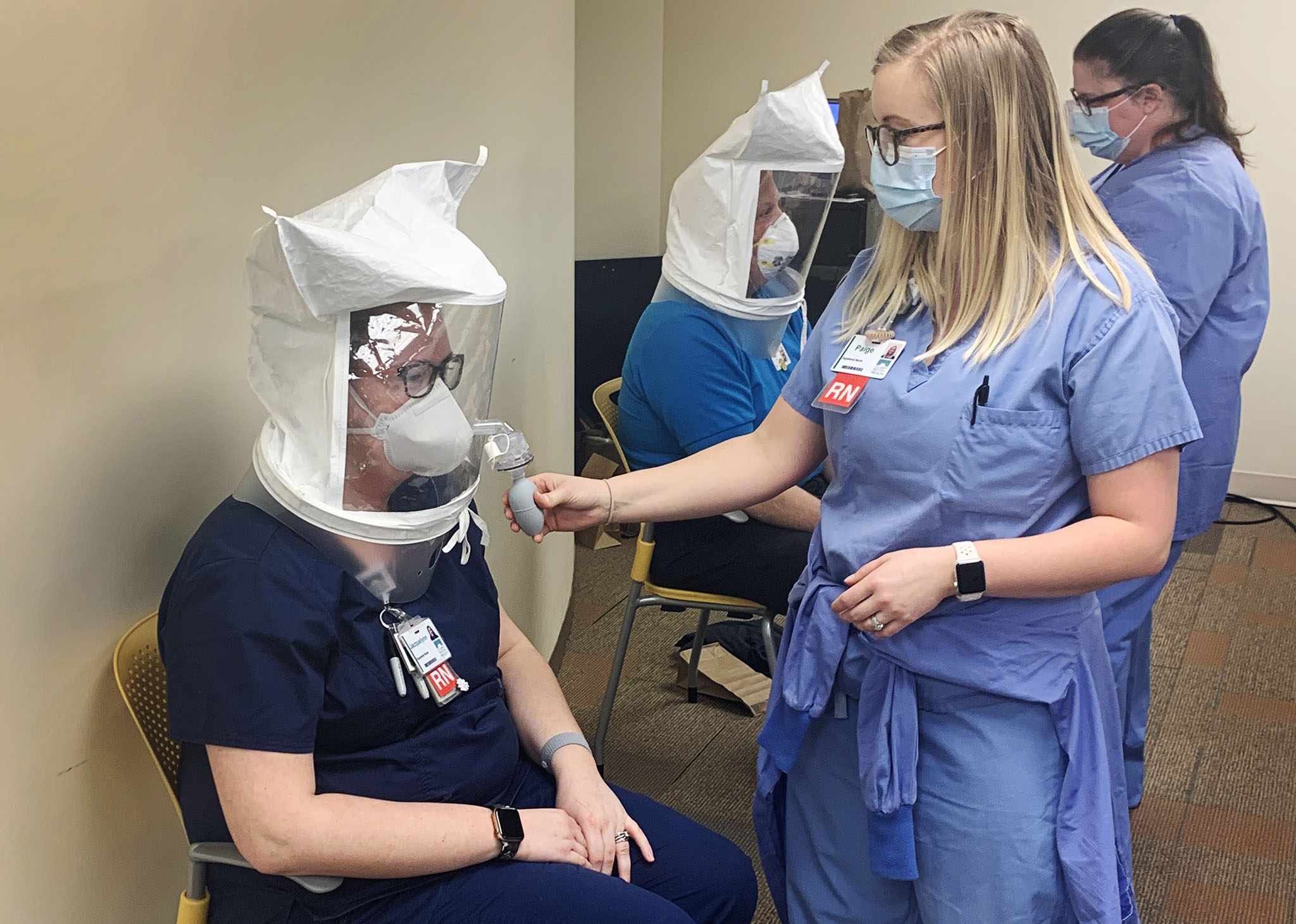 Nurse fit-testing another nurse with an N95 mask.